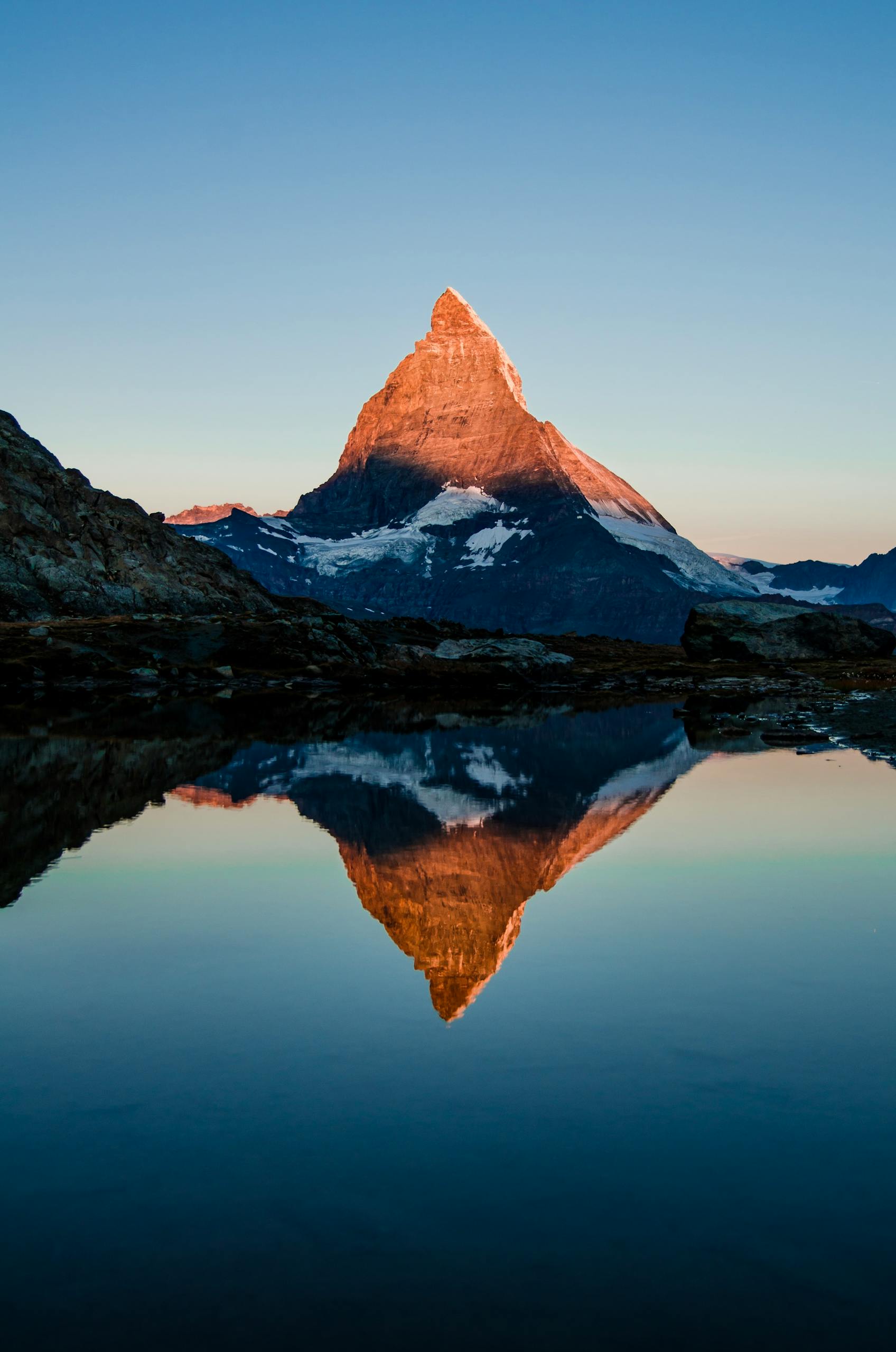 Captivating view of the Matterhorn reflected in a calm lake during sunset, showcasing nature's beauty.